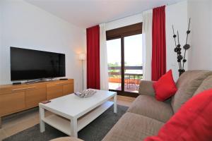 ein Wohnzimmer mit einem Sofa, einem TV und einem Tisch in der Unterkunft Apartment HANNAH in Estepona