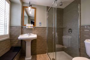 uma casa de banho com um lavatório e uma cabina de duche em vidro. em The Bell & Stuart House em Stow on the Wold