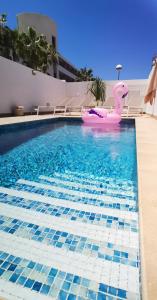 a swimming pool with a pink hippopotamus in the water at Villa Hortensia in Adeje