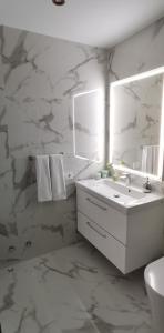 ein weißes Badezimmer mit Waschbecken und Spiegel in der Unterkunft Villa Hortensia in Adeje