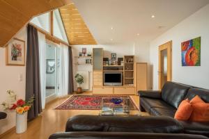 a living room with a leather couch and a kitchen at Ferienwohnung Haidle in Eriskirch