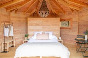 um quarto com uma cama num chalé de madeira em Nits de Bosc em Vilassar de Dalt