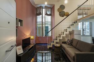 a living room with a couch and a staircase at Atelier Apartments by Wonderful Italy in Genoa