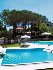 a swimming pool with two umbrellas and two chairs at Villa Rossana in Cenaia