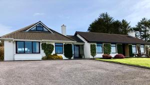 a house with a driveway in front of it at Derrynane Bay House in Caherdaniel