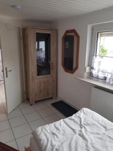 1 dormitorio con puerta de madera y espejo en Holly's Home, en Bad Homburg vor der Höhe