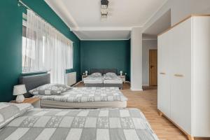 シュツァブニツァにあるPokoje gościnne Włóczykijの緑の壁のベッドルーム(ベッド2台付)