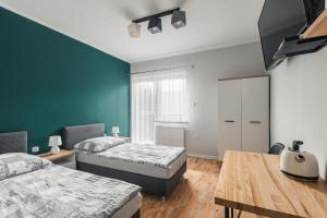 シュツァブニツァにあるPokoje gościnne Włóczykijのベッドルーム1室(ベッド2台、木製テーブル付)