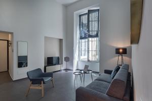 a living room with a couch and two windows at Atelier Apartments by Wonderful Italy in Genoa