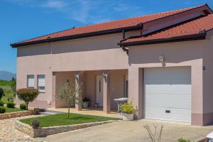 a house with a garage and a driveway at Villa KOD BUBE in Ljubuški