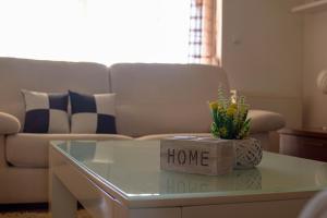 ein Wohnzimmer mit einem Sofa und einem Couchtisch mit einem Home-Schild in der Unterkunft Villa KOD BUBE in Ljubuški