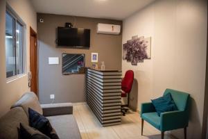 a living room with a couch and a chair and a tv at Hotel Numaz in Sao Paulo