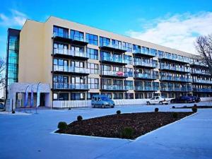 a large building with cars parked in a parking lot at Apartament Andy in Saturn