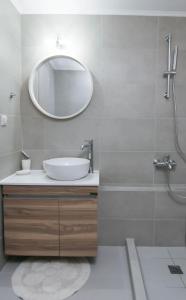 een badkamer met een wastafel en een spiegel bij VAMA APARTMENT in Plataniás