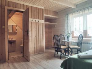 a room with a bed and a table and chairs at Pod Strzechą in Białka Tatrzańska
