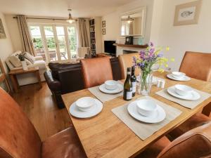 uma sala de jantar com uma mesa de madeira e cadeiras em The Wash House em Bembridge