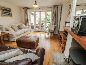 uma sala de estar com um sofá e uma mesa em The Wash House em Bembridge