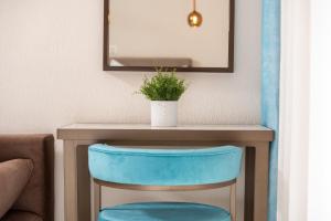 a blue stool in front of a table with a mirror at VagAthan - Lux Holidays in Afitos