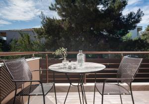 a table with chairs and a bottle of water on a patio at VagAthan - Lux Holidays in Afitos