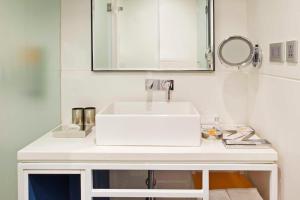 a bathroom with a white sink and a mirror at Zone By The Park Coimbatore in Coimbatore