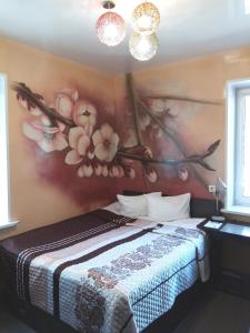 チェレポヴェツにあるАРТ-Отельの花の壁画が壁に施されたベッドルーム
