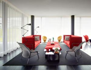 a living room with red chairs and a red couch at citizenM Paris Charles de Gaulle Airport in Roissy-en-France