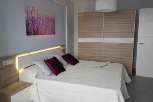 プエルト・デ・ラ・クルスにあるApartamento con Terraza y Piscina Cのベッドルーム(白いベッド、赤い枕付)