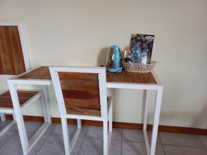 un escritorio blanco con una silla y una mesa con una taza en SUWON homestay, en Mojokerto