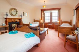 a living room with two beds and a fireplace at Balintore Inn in Balintore