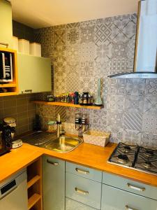 a kitchen counter with a sink and a stove at Résidence Nicoleta à Westende in Westende-Bad