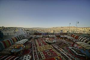 a room with a table and chairs with a rug at Cappadocia Cave Lodge in Goreme