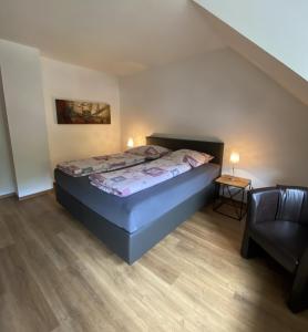 een kleine slaapkamer met een bed en een stoel bij Ferienweingut Göbel in Traben-Trarbach