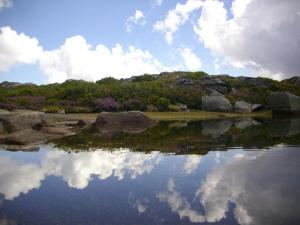 un reflejo del cielo en un cuerpo de agua en Salto do Lobo - Montain houses with private river en Penhas da Saúde