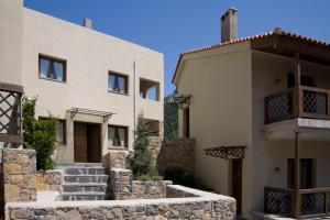 a white house with a stone wall next to it at Guesthouse Vasiliki in Steni Dirfyos
