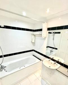 a white bathroom with a tub and a sink at Purdy Lodge in Belford