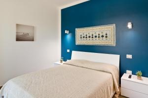Un dormitorio con una pared azul y una cama. en Sunshine apartment, en Su Forti
