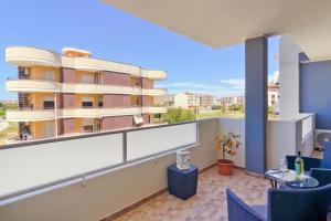 un balcón con sillas azules y un edificio en Sunshine apartment, en Su Forti