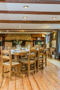 uma sala de jantar com uma mesa de madeira e cadeiras em Dyke Farm Barn near Brighton by Huluki Sussex Stays em Brighton & Hove