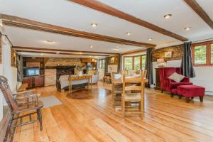 a living room with a table and chairs and a fireplace at Dyke Farm Barn near Brighton by Huluki Sussex Stays in Brighton & Hove