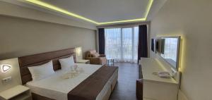 ソゾポルにあるHotel Sunnyのベッドと大きな窓が備わるホテルルームです。