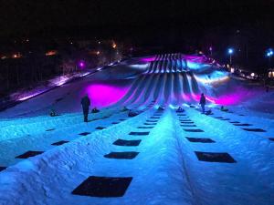 a snow covered ski slope at night with people on it at The Summit at Massanutten Resort by TripForth in McGaheysville