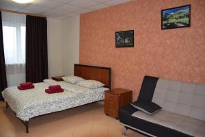 ein Schlafzimmer mit einem Bett, einem Sofa und einem Stuhl in der Unterkunft Voskhod Hotel in Kiew