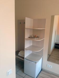 un armario con estanterías blancas en una habitación en Kambarių nuoma - Šiauliai SAURIDA, en Šiauliai