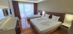 een hotelkamer met 2 bedden en een badkamer bij Hotel Sunny in Sozopol