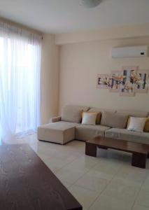 ein Wohnzimmer mit einem Sofa und einem Couchtisch in der Unterkunft T&E Apartment in Larnaka