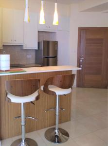 a kitchen with a counter and two bar stools at T&E Apartment in Larnaka +1 photo