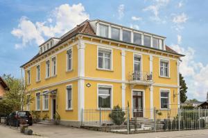 uma casa amarela com uma cerca em frente em Apartment Tuna em Sigmarszell