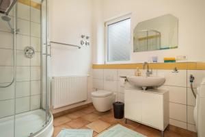 a bathroom with a toilet and a sink and a shower at Apartment Tuna in Sigmarszell +13 photos