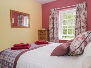 a bedroom with a bed with red towels on it at Mount Pleasant Cottage in Grange Over Sands