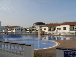 duży basen z czarnym parasolem w obiekcie 2 Bedroom Apartment , Son Bou w Son Bou
